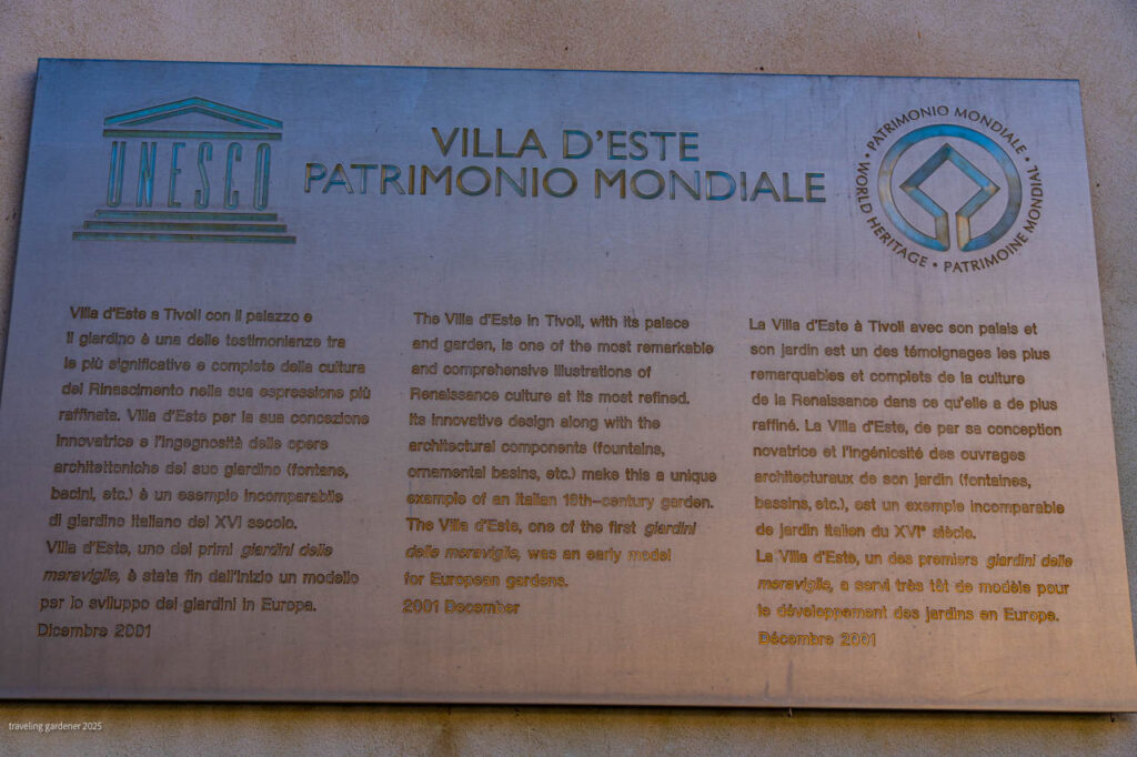 UNESCO plaque at Villa d'Este, Tivoli, with Italian, English, and French text about its Renaissance garden and the UNESCO emblem on the left and World Heritage seal on the right.