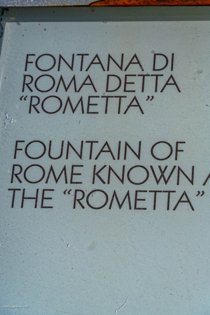 Signboard showing Fontana di Roma detta 'Rometta' with English translation: 'Fountain of Rome known as the "Rometta"'