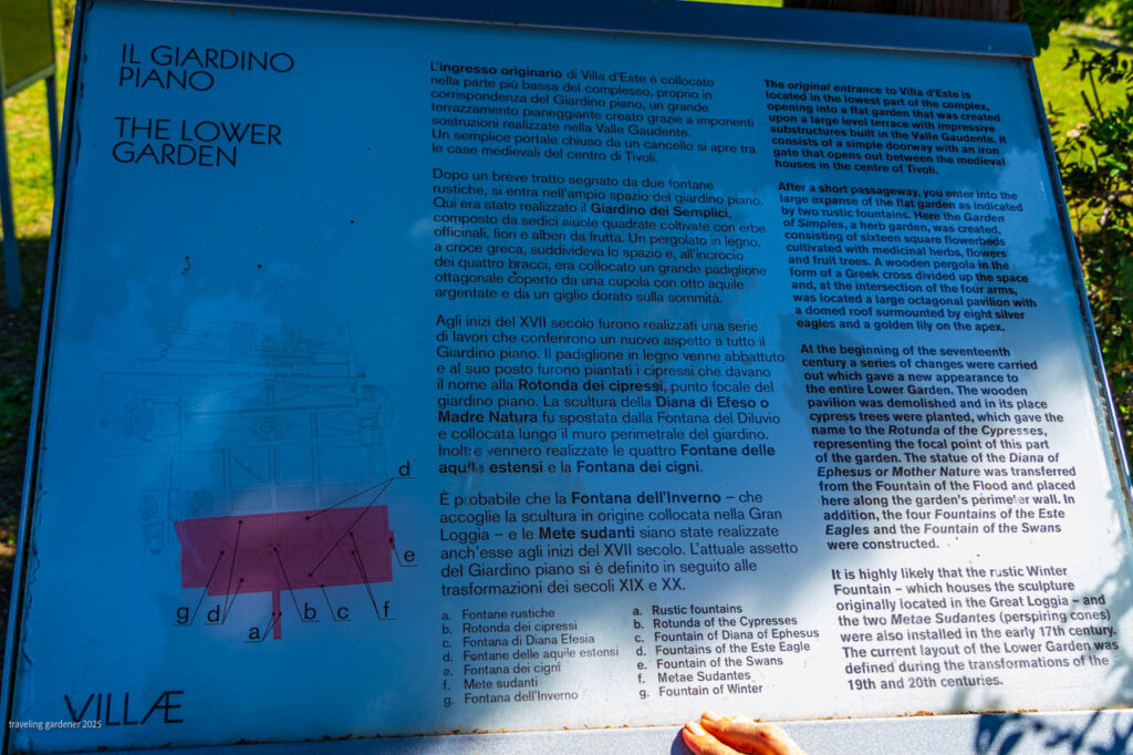 Blue informational sign titled 'Il Giardino Piano / The Lower Garden' explaining the garden's history, with a schematic diagram in purple and blocks of Italian and English text.