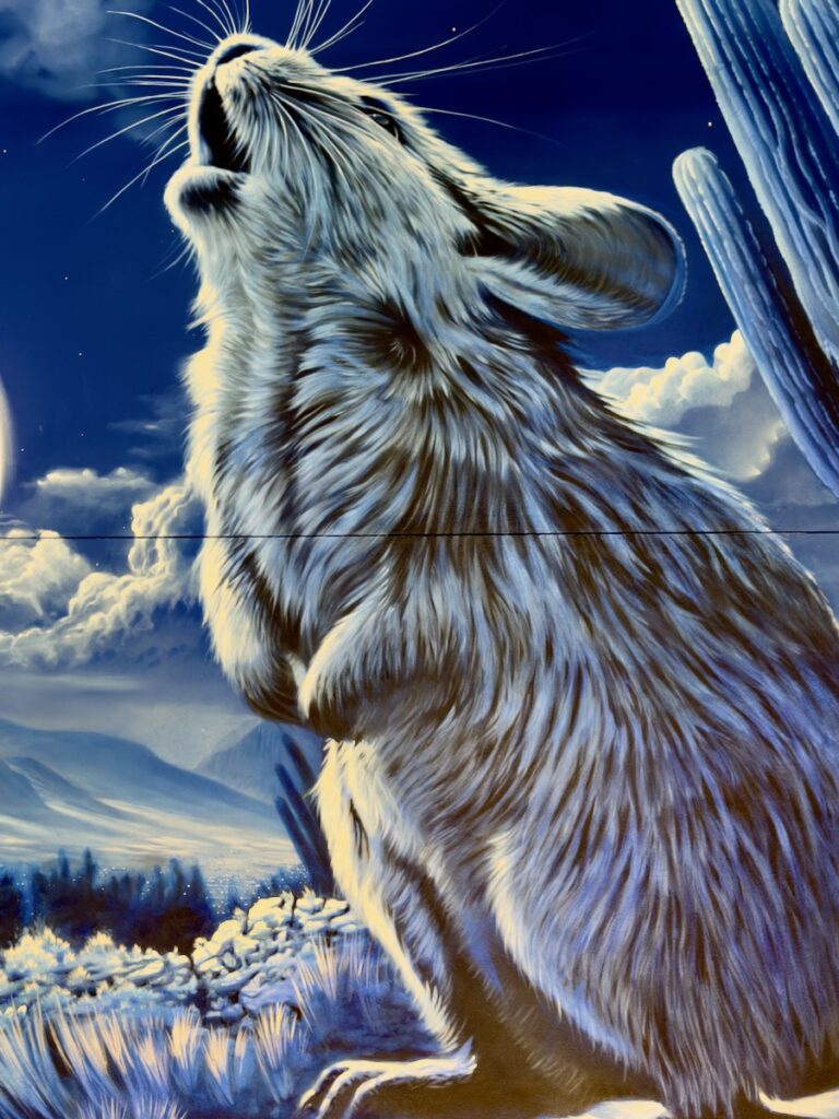 Blue-toned painting of a hare standing on a snowy landscape with its head raised, as if calling, against a sky with clouds and distant mountains.
