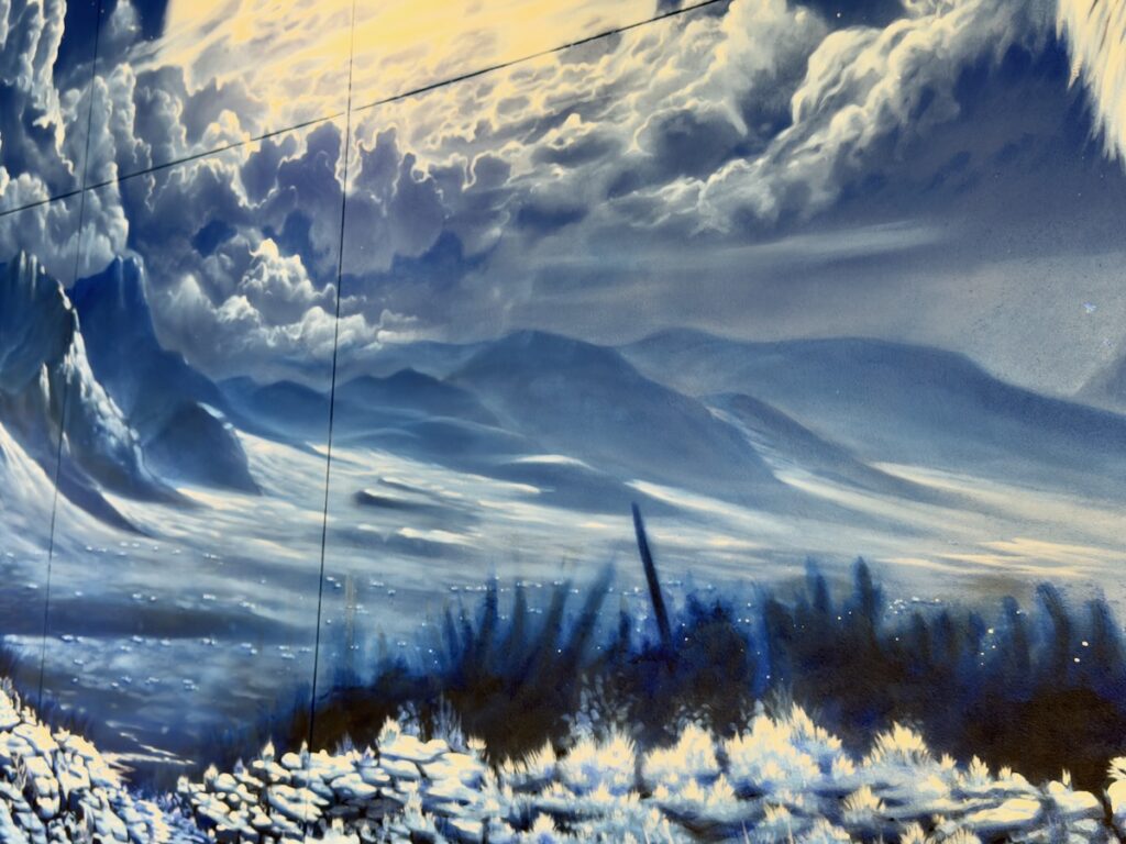 Blue-toned mural of an icy landscape with mountains, snow, and cloudy sky.