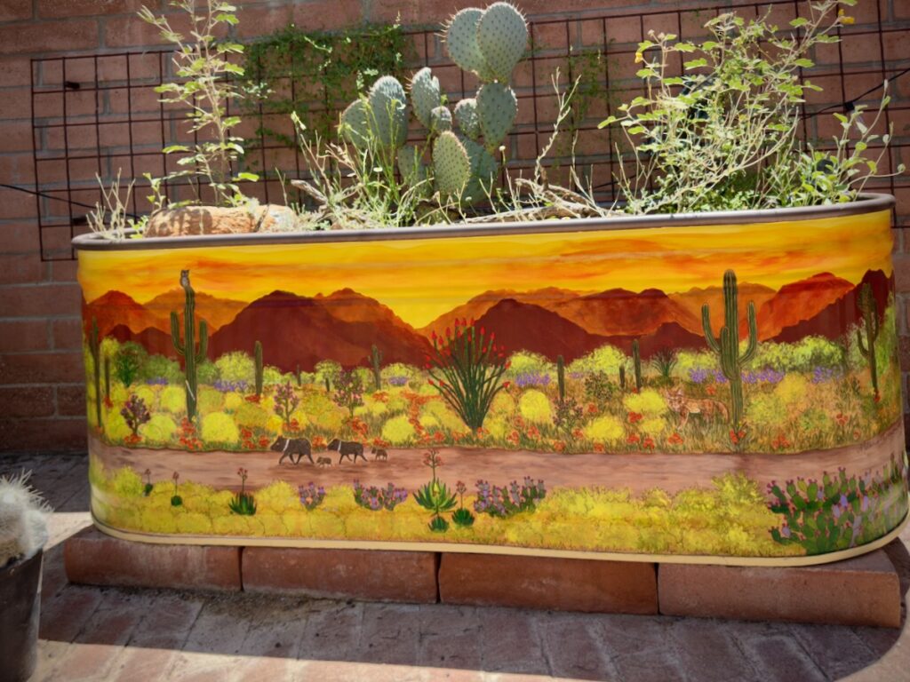 Painted desert landscape planter with cacti, cacti silhouettes, and a sunset over mountains.